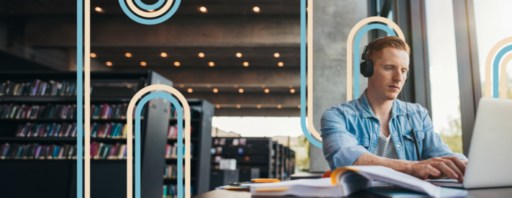Photo montrant un étudiant travaillant sur son ordinateur dans une bibliothèque.